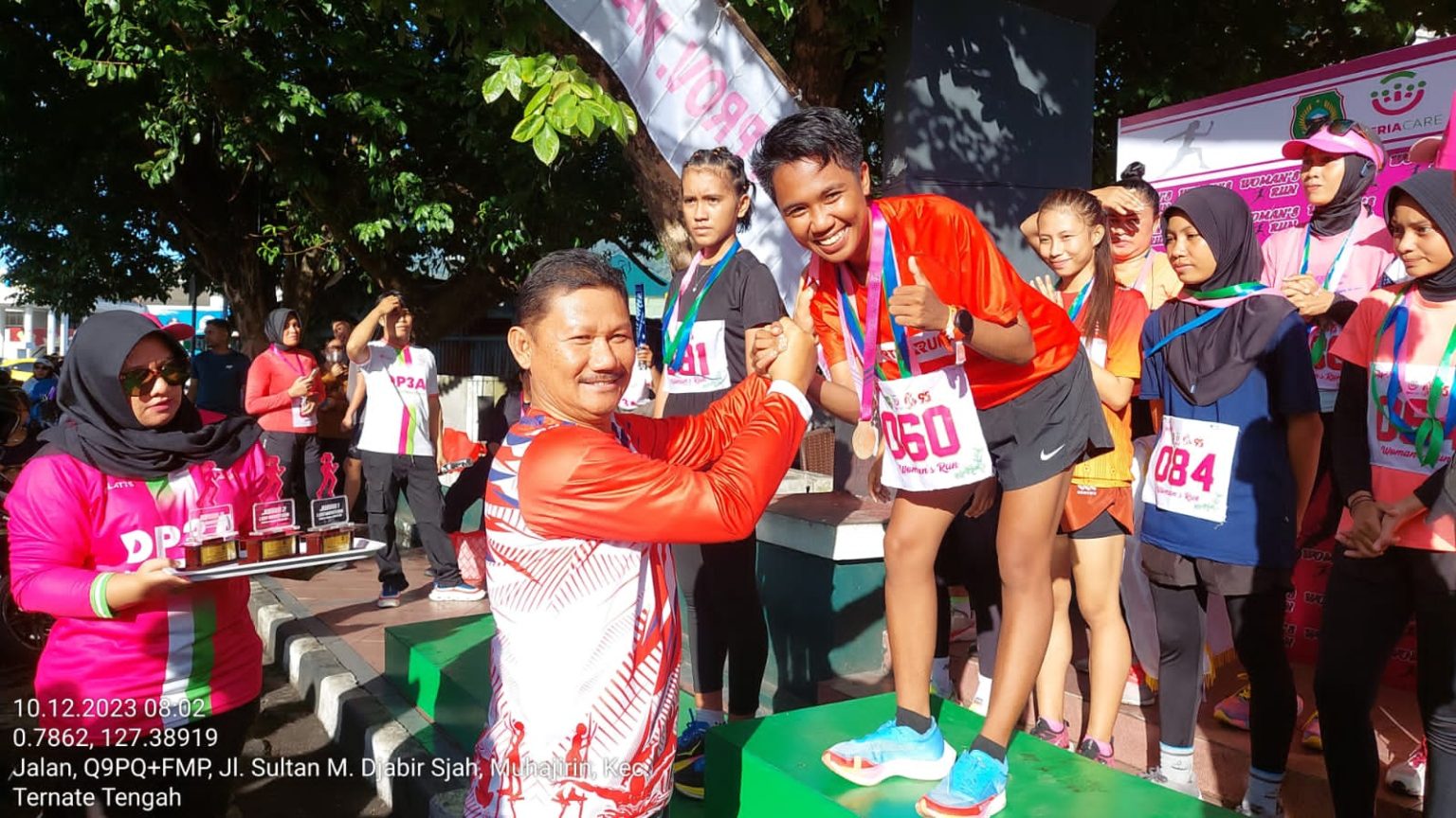 Staf Ahli Gubernur Bidang Ekonomi, Keuangan dan Pembangunan Mulyadi Wowor saat menyerahkan hadiah kepada pemenang pertama lomba Women's Run.
