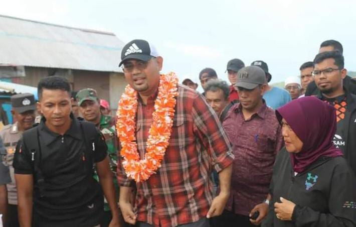 Warga Kayoa kalungkan bunga ke Bassam Kasuba Bupati Halsel saat Kunker penutupan Khatulistiwa Cup di Desa Guruapin (foto_Sadam//sm)