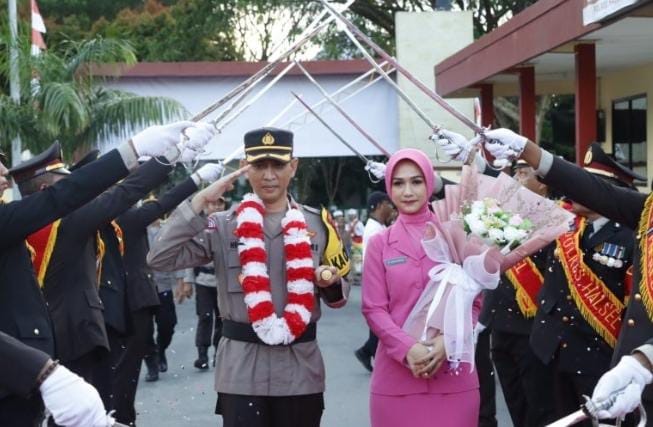 AKBP Hendra Gunawan dan istri hendak masuk di gerbang Mapolres Halsel (Dok//Sadam)